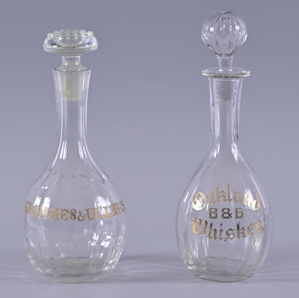 Antique Etched Glass Whiskey Decanters (2): Whiskey Advertising Etched Glass Decanters. Oakland B & B Whiskey. Grommes & Ulrigh, chips on top edge and stopper. Both measure 8 3/4 inches tall w/o stoppers.
