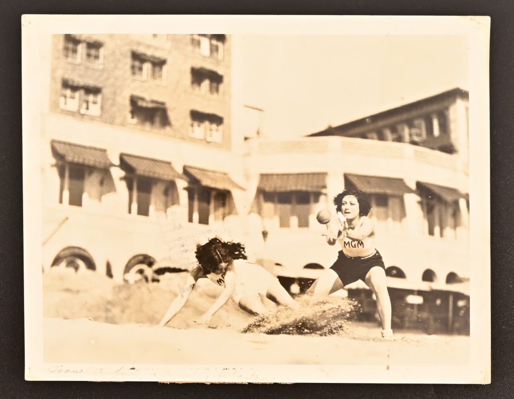 Joan Crawford, Dorothy Sebastian Rare MGM Photo: Rare MGM publicity photo of Joan Crawford & Dorothy Sebastian playing ball on the Santa Monica Beach, circa 1928. "Return To Screen File" stamped on back, along with International Newsreel stamp. Phot