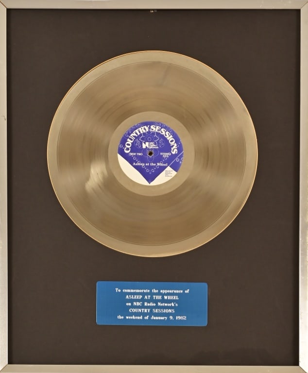 Asleep At The Wheel Country Sessions Plaque 1982: Commemorative record presented to Asleep At The Wheel for their appearance on NBC Radio Network's Country Sessions on th weekend of January 9, 1982. Frame measures 18 3'4" x 23 1/4".