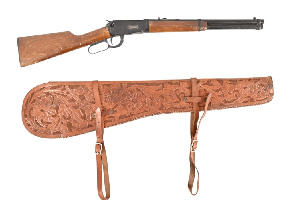 Yellowstone 1923 Rifle Scabbard And Prop Rifle: From the popular TV series Yellowstone. Tooled leather rifle scabbard and rubber Winchester 1894 prop rifle. Scabbard measures 35 1/4" long.