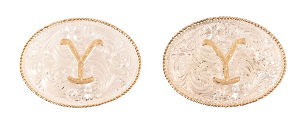 Yellowstone Dutton Ranch Belt Buckles 2: Both by Montana Silversmiths are oval silver finished featuring bright-cut floral scrolls, a twisted gold-colored rope trim, and the iconic gold "Y" brand in the center. One is inscribed on back "Many