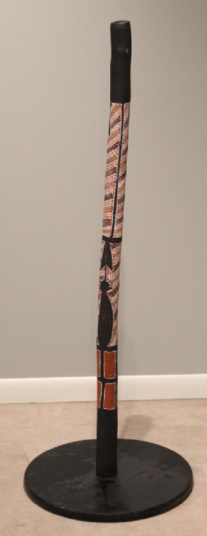 Vintage DIDGERIDOO ABORIGINAL INDIGENOUS NATIVE MADE: Details: Vintage DIDGERIDOO ABORIGINAL INDIGENOUS NATIVE MADE TRADITIONAL MUSIC AUSTRALIAN 20th C with Stand Musical Instrument This lot consists of a vintage 20th C Aboriginal or indigenous made didg