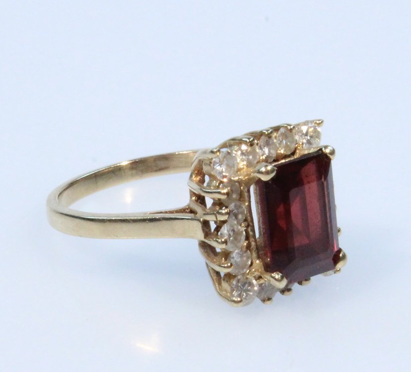 Precious Gemstones 14K GARNET & DIAMOND RING Vintage: Details: This lot consists of the tested garnet and diamond ring shown in the corresponding images. This 14 karat yellow gold ring is set with a 2.5 carat emerald-cut Rhodolite garnet, surrounded by 1