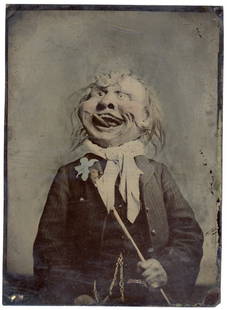 BIZARRE MASK GRINNING LARGE TINTYPE: Approximately 6½ x 4¾ inches.The creature is grinning, but there are eerie undertones to this fabulous tintype. File this under the 'as strange as they come' category. A thoroughly engag