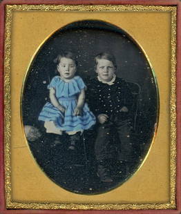 CHILDREN EQUAL HEIGHT, THE YOUNGER WEARS BLUE DRESS: Sixth plate daguerreotype.They are adorable seated side by side, with their faces at the same height. The older child sports three sets of vertical buttons, the other child shows off a bright blue