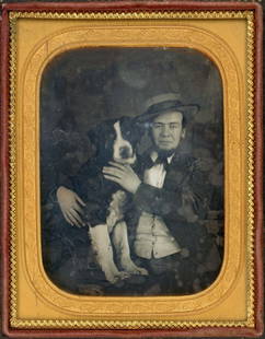 MAN CRADLING HIS DOG DAGUERREOTYPE: Quarter plate daguerreotype.The man has both hands on the dog, in a loving manner, holding the dog steady for the photographer. The man has a slightly amused expression on his face. The dog's head is