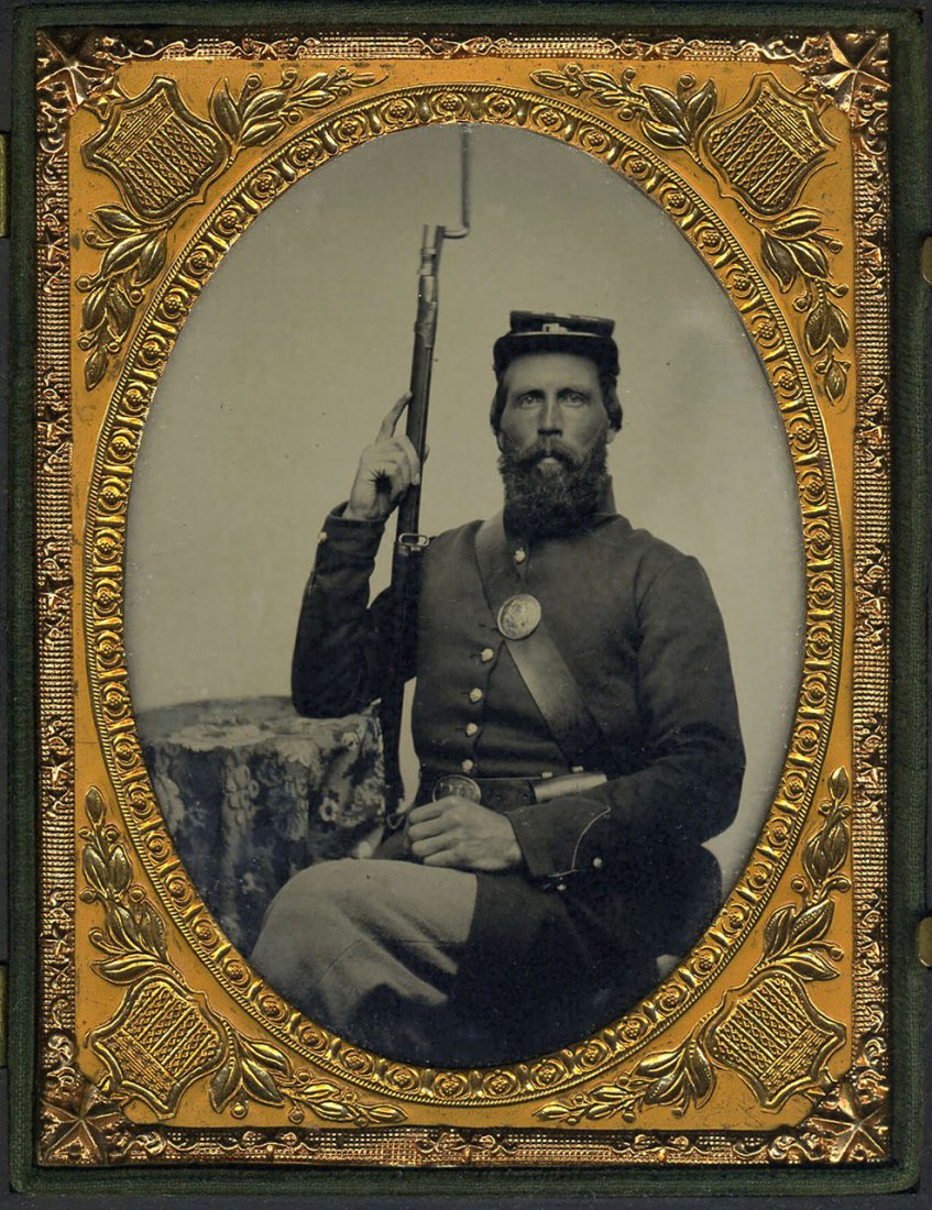 CIVIL WAR SOLDIER, RIFLE & BAYONET: Quarter plate ruby glass ambrotype. Cupid And the Wounded Stag Union Case. It's the pose that sets this apart from other Civil War ambrotypes. Not only is the rifle and bayonet pointed upward in a sea