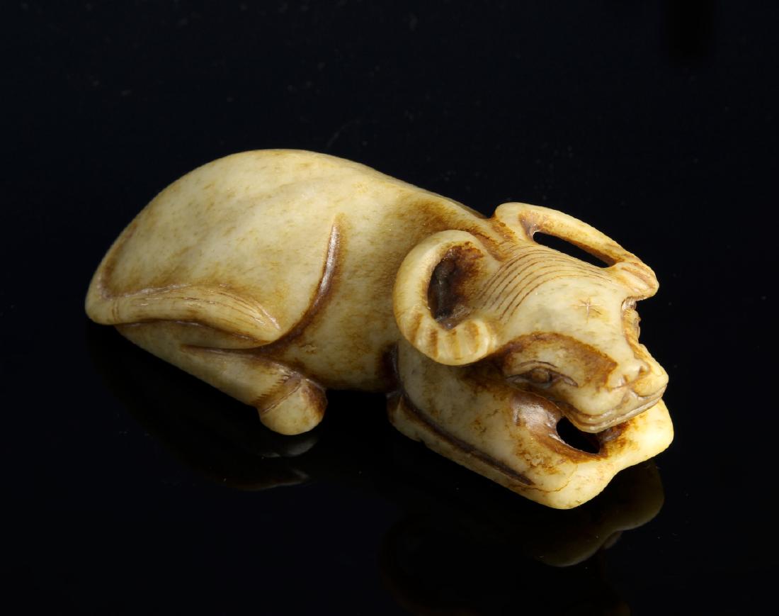 Chinese Jade Cow: China, Ming Period, jade cow, in reclining position, with simplistically carved features, in a brown hue, with striations in the stone. Length 4 1/4 in.
