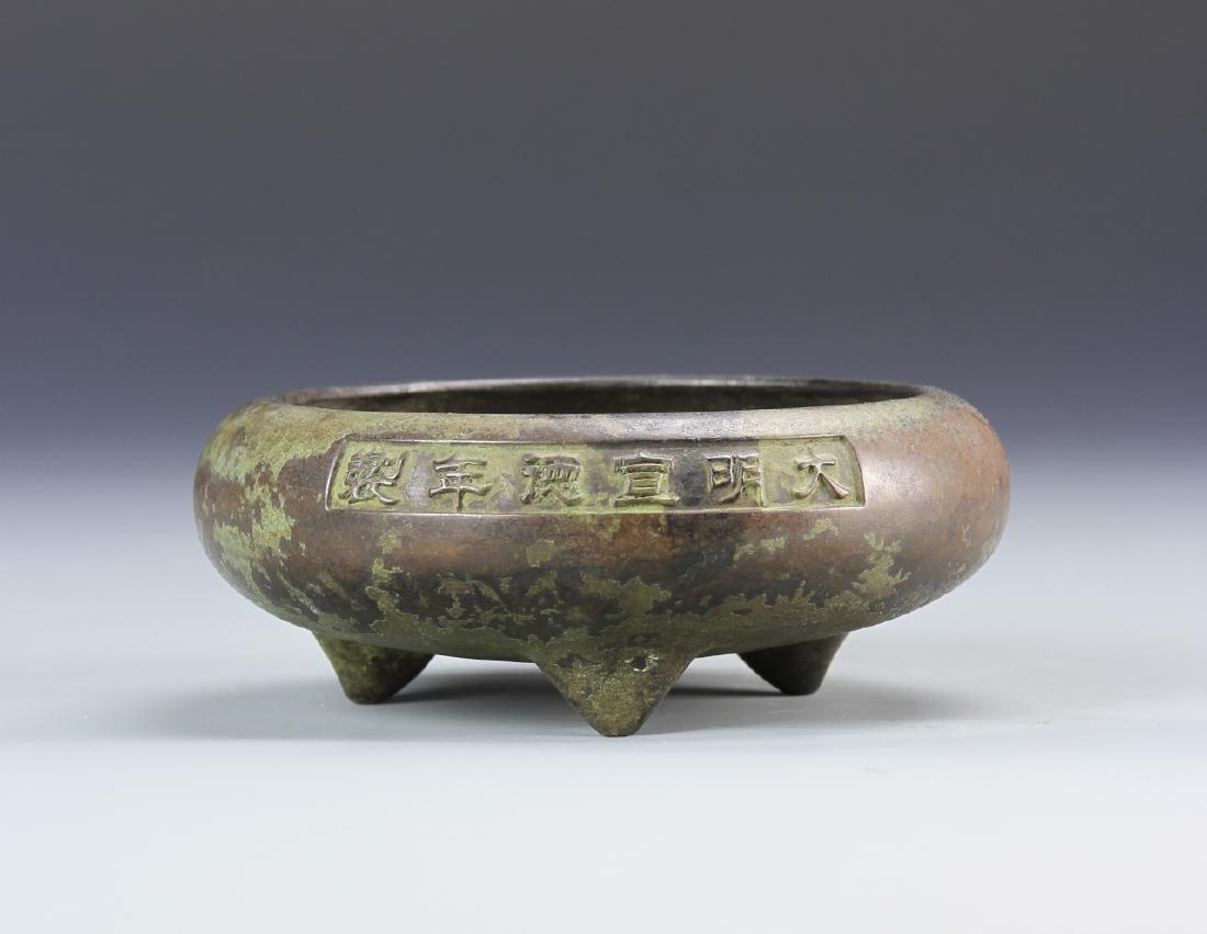 Chinese Bronze Tripod Censer: China, Qing dynasty, bronze tripod censer, flattened round body, patina throughout, calligraphy signed on one side in a panel and Ming mark on the base. Diameter 5 in., Height 1 7/8 in.