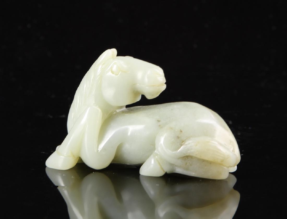 Chinese Jade Horse: China, 19th C., jade horse, in a reclining position, with simplistically carved body, in a light green hue, with striations in the stone. Width 2 1/4 in., Height 1 1/2 in.