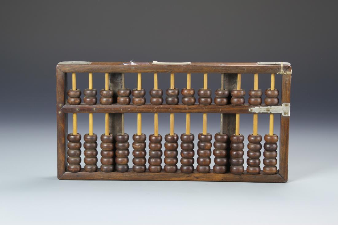 Chinese Huanghuali Abacus: China, ROC Period, Huanghuali Abacus, traditional thirteen strands of counting beads, with two on the top and five on the bottom, with metal hinges. Length 13 3/4 in., Height 7 in.