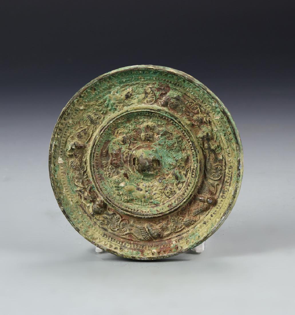 Chinese Bronze Mirror: China, antique bronze mirror, with raised, incised circular motifs on one side, heavy patina throughout the surface. Diameter 4 7/8 in.
