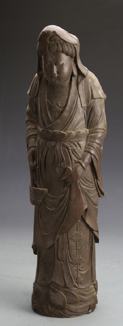 Chinese Carved Bamboo Guanyin Figure: China, carved bamboo figure of Guanyin, in a standing position, wearing flowing robes and carrying a basket.
