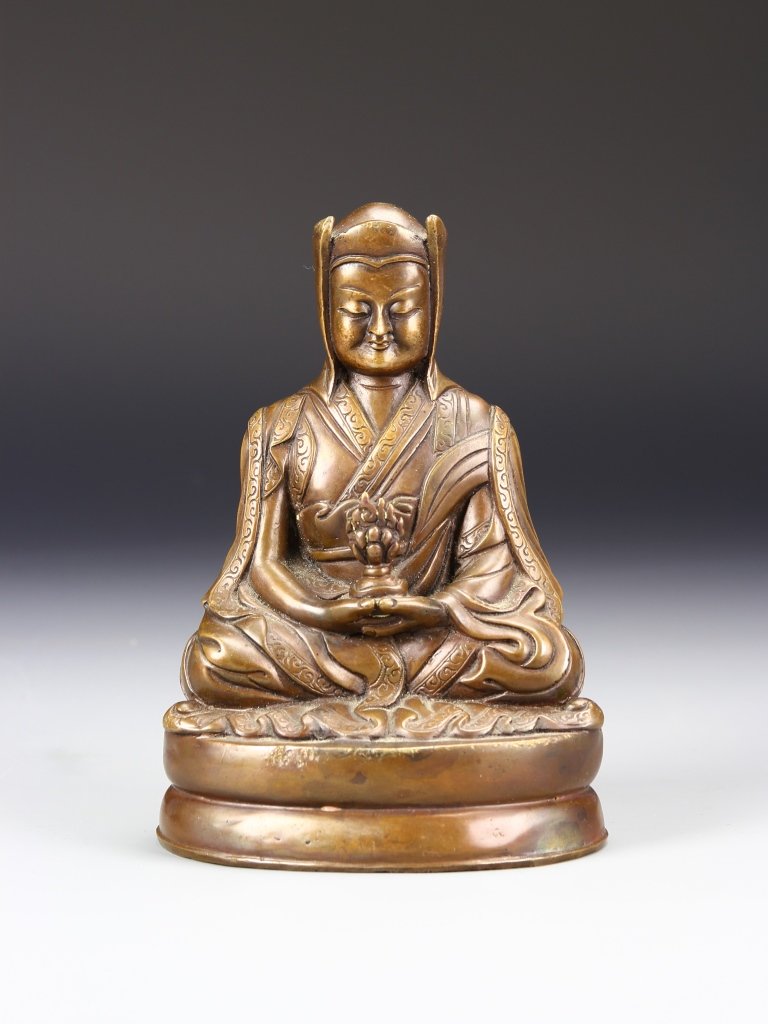 Chinese Bronze Buddha: China, bronze Buddha, in a seated pose, on a raised base, with hands clasped, holding a lotus flower, with detailed robes. Height 6 1/4 in.