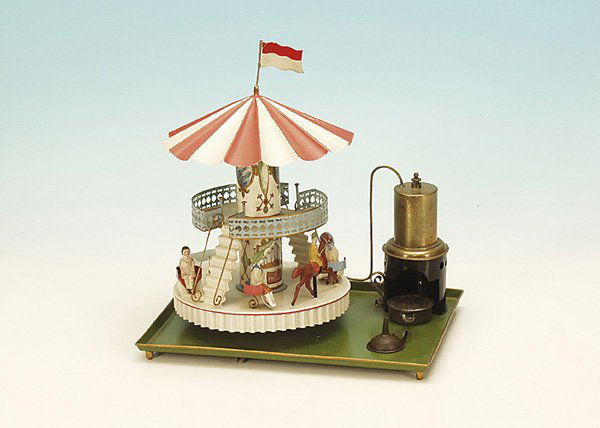 Hommolla Dampfkarussell, pseudo Turbinenantrieb: Grundplatte 33 x 26 cm, komplett n e u l a c k i e r t, mit 4 Replika Sitzfiguren, Karussell mit 2 Etagen und Treppenaufgang, kleiner stehender Dampfkessel, Brenner vorhanden, der Antrieb dieses Karus