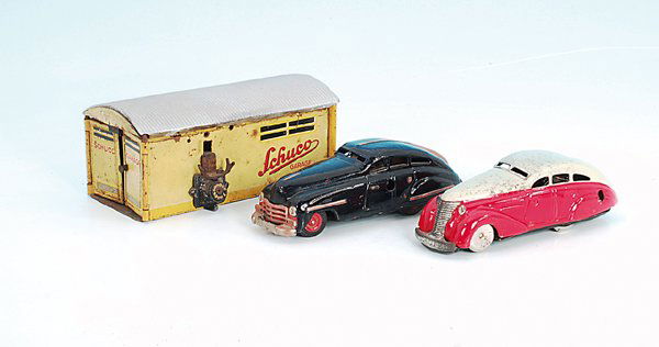 2 SCHUCO Autos FEX 1111und SCHUCO Garage Nr. 1500: Autos schwarz und rot/creme, deutliche Gebrauchsspuren.