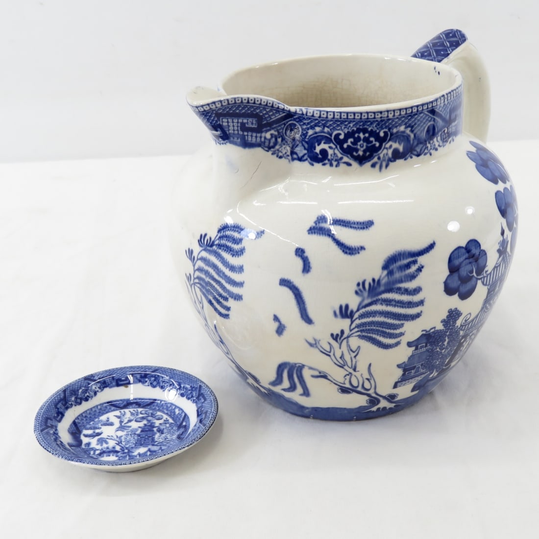 1909 Buffalo Pottery "Blue Willow" Pitcher & Pat: 6.5" water jug / pitcher, and 3 3/8" butter pat plate. both bottom marked : "Semi-vitreous (buffalo) Buffalo pottery 1901" All antique items have wear consistent with age please review all photos, and