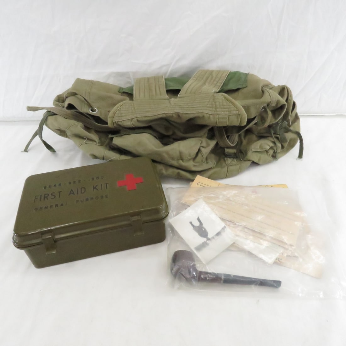 US Military First Aid Kit, Canvas Bag & Ephemera: Hesson Guard pipe and photo from 1941, "Fall-In", newspaper and other items from WWII era, military leave pass, selective service card, and more Please read terms & conditions and ask questions before
