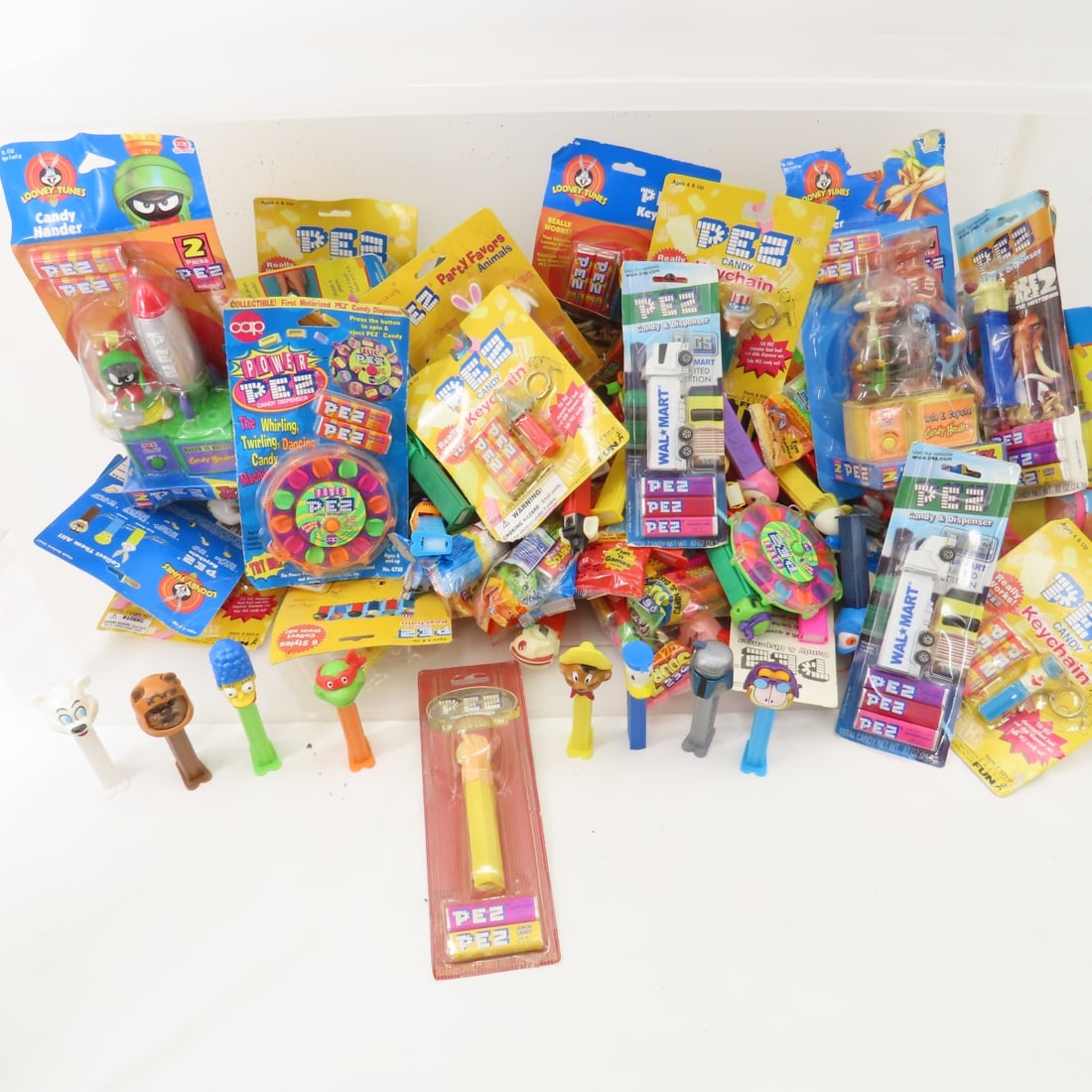 PEZ dispensers and candy some NIP: PEZ dispensers and candy some NIP Warner Brothers, Looney Tunes, cars and others Please read terms & conditions and ask questions before bidding.