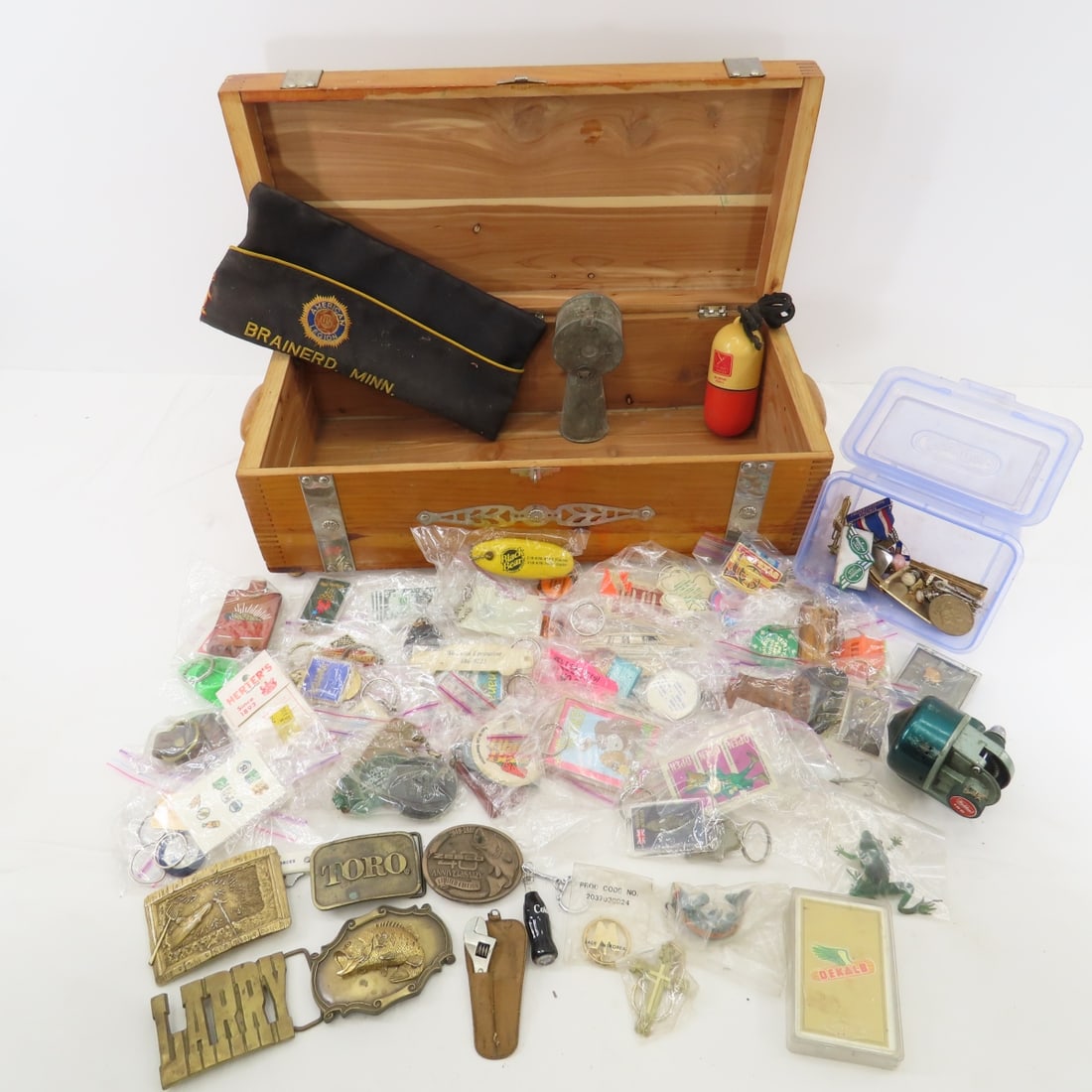 Keychains, Belt Buckles, Fishing Items & More: Keychains, Belt Buckles, Fishing Items & More in wooden box 19x9x7" dusty has been in storage. Please read terms & conditions and ask questions before bidding.