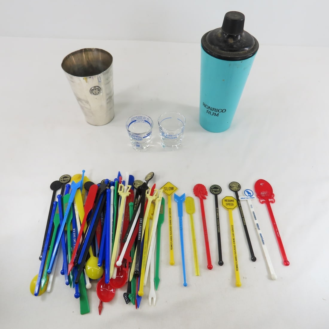 Great Northern Drink Mixer, Stir Sticks & More: 5" silver plate mixer top marked GN, and bottom marked 'International Silver Co GNS 1 GN assorted railroad stir sticks in Ronrico mixer, 2 shot glasses. From the Collection of Don L. Hofsomer. Please 