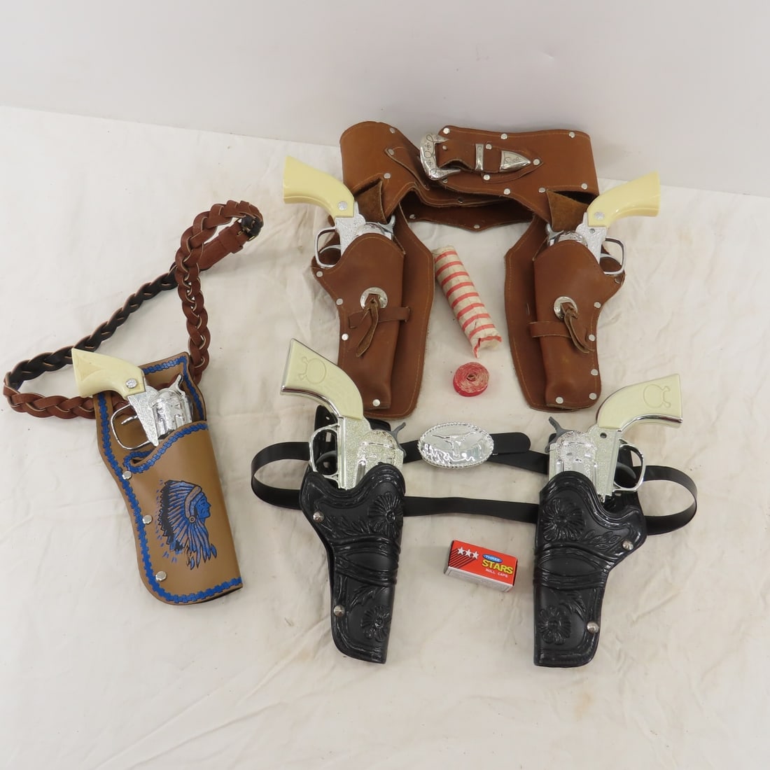 7 Cap Guns, Holster Belts & More: 7 Cap Guns, Holster Belts & More - 2 Durango in black plastic holster belt, made in China pair in brown leather holster belt, and cap gun with Indian chief in holster belt, and roll caps Please ask qu