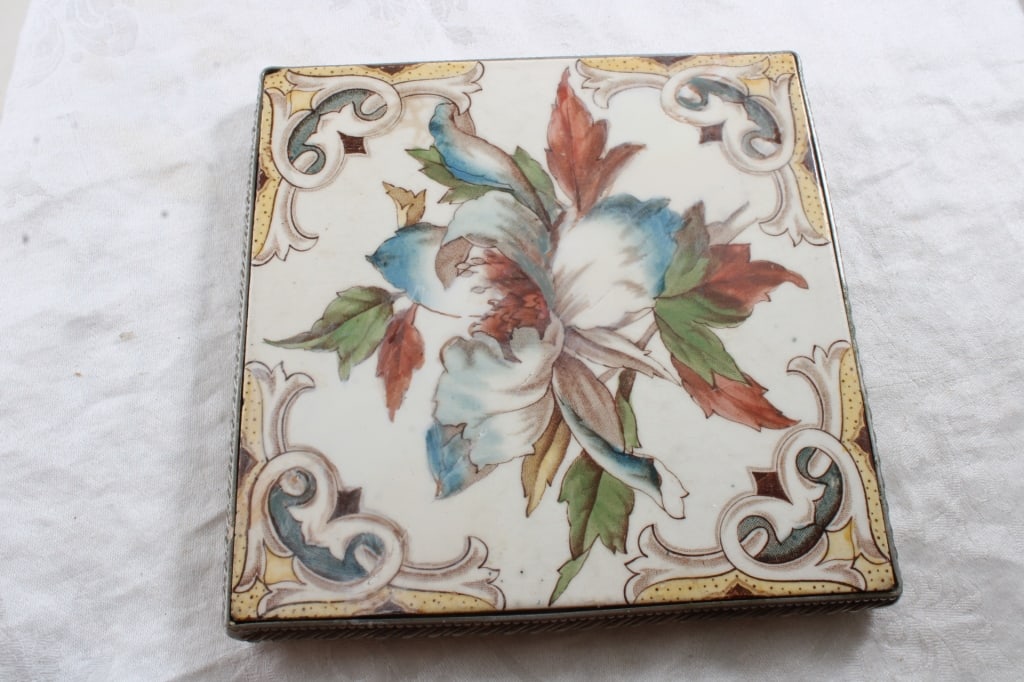 L.T. Made in England Floral Trivet 6" x 6": L.T. Made in England Floral Trivet 6" x 6" - Silver metal Border as pictured. Please ask questions and read terms & conditions before bidding.