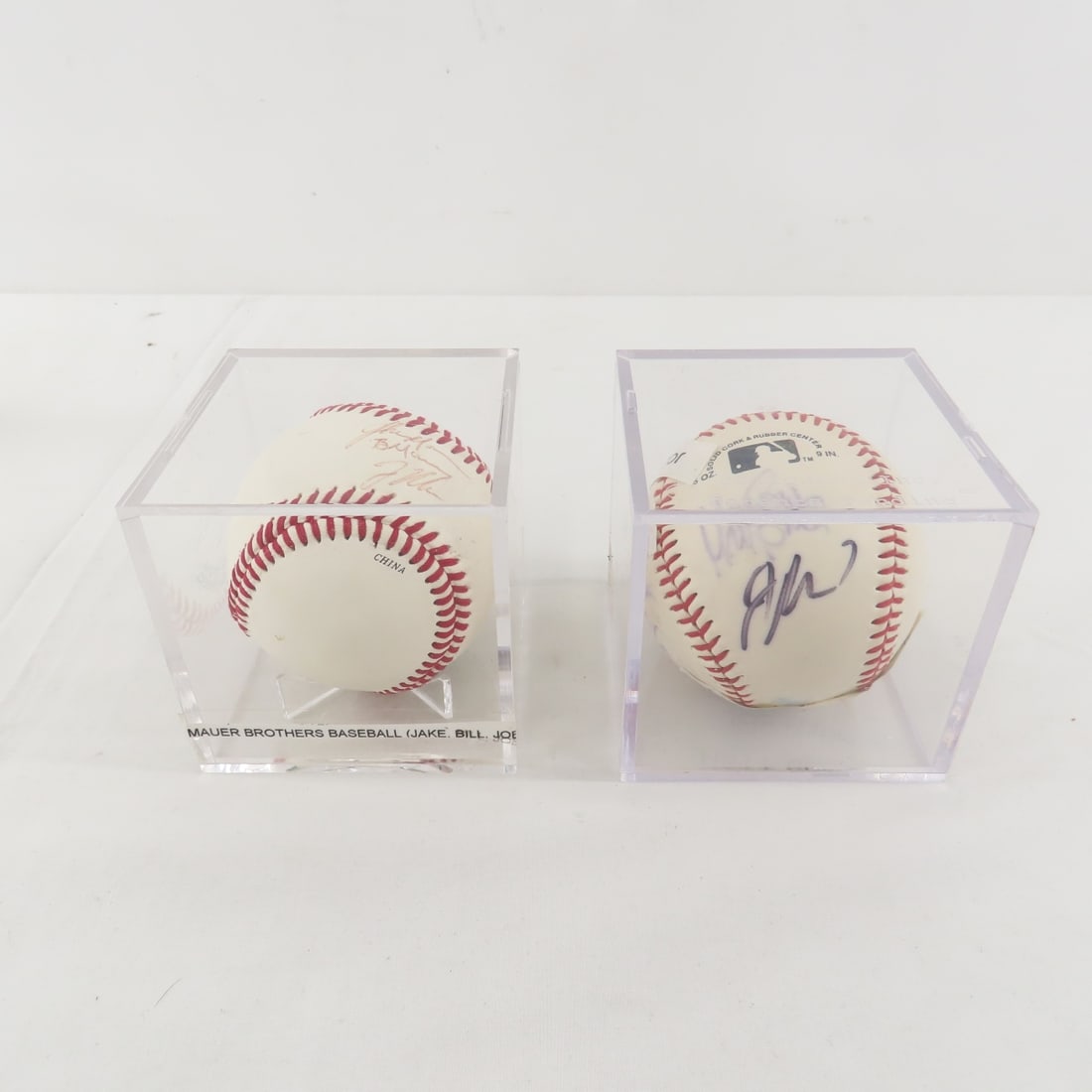 Mauer Brothers & Mauer and 3 Others Signed Balls: Mauer Brothers & Mauer and 3 Others Signed Balls -1 ball has Jake, Bill & Joe Mauer autographs, and the other has Joe Mauer, Matt Guerrier, Joe Nathan and Lew Ford. no COA's in plastic cases Please as