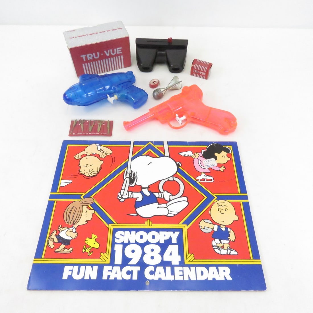 1984 Peanuts Calendar, Toy Water Gun, & More: 1984 Peanuts Calendar, Toy Water Gun, & More-Mattel Shootin Shell Snub nose .38 Revolver with Holster, Toy Ammo & Sheriffs Badge. Cast Aluminum Toy Spurs, 2 Water Pistols, Toy Cap Grenade & Caps, 1984