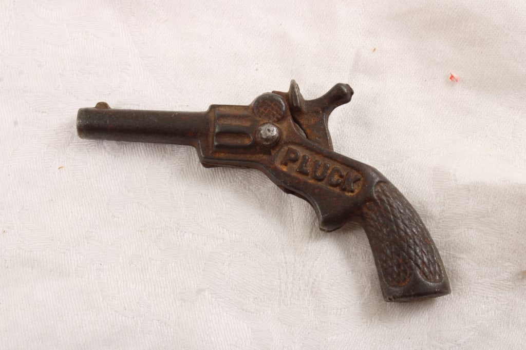 Cast Iron Small PLUCK Cap Gun: Cast Iron Small PLUCK Cap Gun - Measures 4" Long. As pictured. Please ask questions and read terms & conditions before bidding.