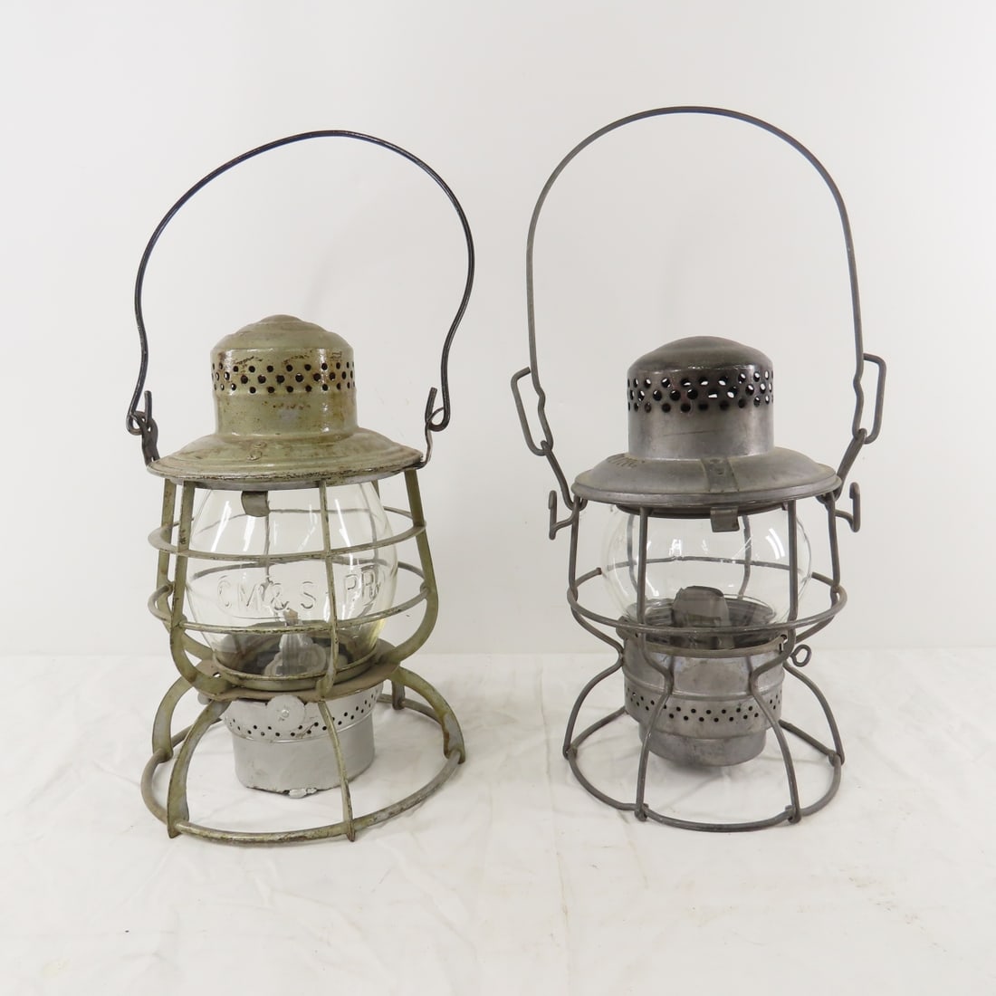 CM&STP RY Armspear & BN Inc. Lanterns: CM&STP RY Armspear & BN Inc. Lanterns - 1) "CM&STP RY" tall clear Corning cast globe with very minor edge chips, Armspear Lantern- bottom is damaged, no RR mark. Fount, Armspear burner and wick. 2) "B