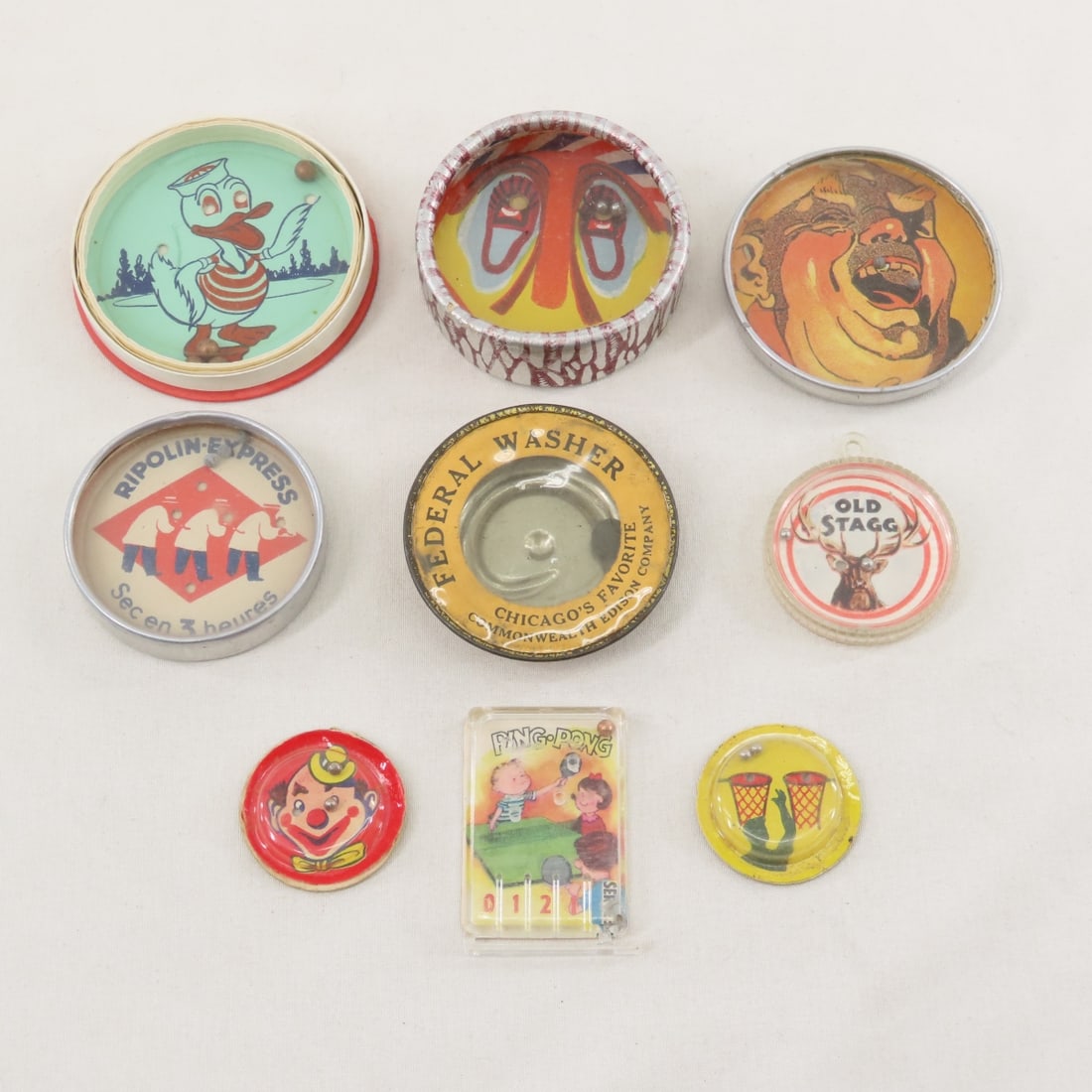 Advertising and Cracker Jack Dexterity Puzzles: Advertising and Cracker Jack Dexterity Puzzles - 2 1/8" guy missing 2 teeth Parisian Hat Shop tin advertising, 1 7/8" Ripolin Express 5 bead puzzle, 2" Federal Washer Chicago, Union Ice Cream Made in