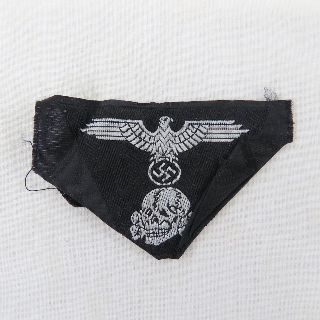 WWII German Waffen SS Panzer M43 cap insignia: WWII German Waffen SS Panzer M43 cap insignia - BeVo trapezoid, does not glow under a black light. Lot Size 3x3x1" 1lb Photos are part of description. Live Auctioneers displays a max of 20 photos-