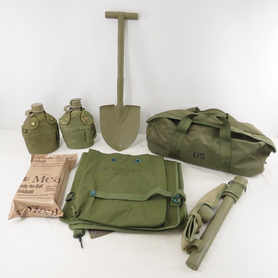 Vintage US Military Entrenching Tool, M2A1 Bag: Vintage US Military Entrenching Tool, M2A1 Bag - MRE, 2 Canteens, possible reproduction M1910 Shovel, Small duffle bag. Lot size: 19 x 14 x 10", 12 lbs Photos are part of description. Live