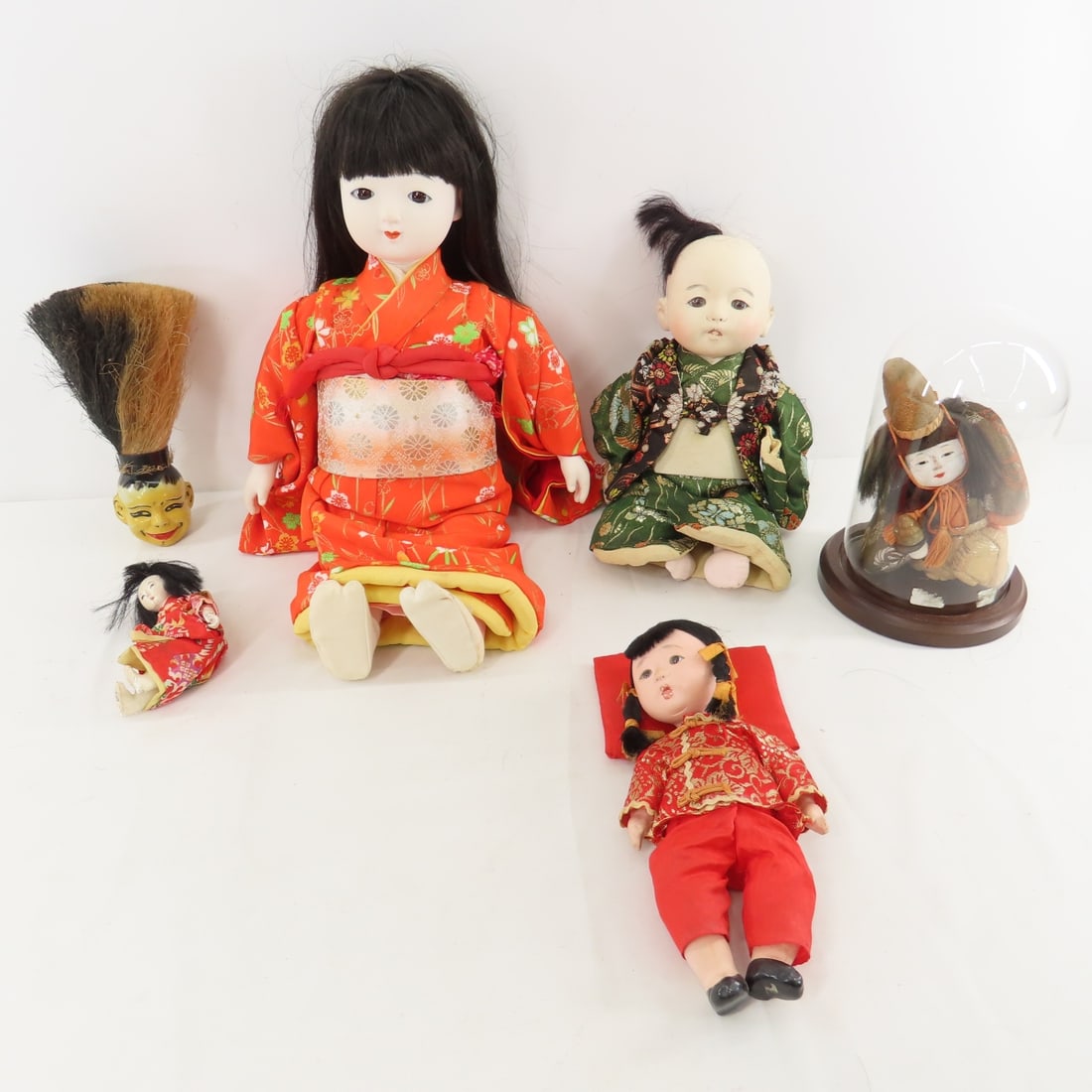 4 Asian Dolls & Clothes Brush: 4 Asian Dolls & Clothes Brush - Tallest is 16" hard plastic with cloth body, compo baby in green has damage (partially missing leg & cracks on head), sitting fabric & compo (damaged face) in 7"