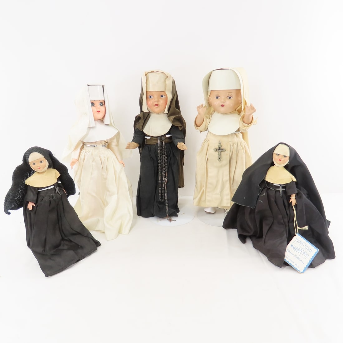 2 Composition & 3 Plastic Nun Dolls: 2 Composition & 3 Plastic Nun Dolls - 2 Compo are circa 1930's and are12" tall on stands, nun in white has a chipped thumb. did not remove outfits to look for marks as they are fragile and pin on.