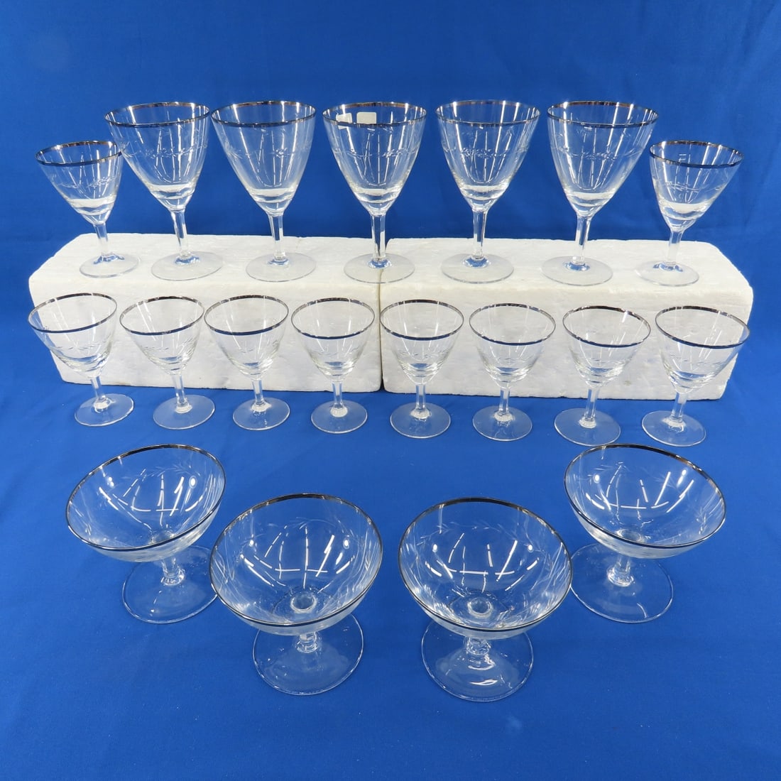 German Laurel Leaf Silver Rim Clear Glassware: German Laurel Leaf Silver Rim Clear Glassware - 4 3.5" champagnes, 10 4.75" glasses, 5 6" glasses. No chips or cracks. Lot size: 18x15x6", 5 lbs Photos are part of description. (Live Auctioneers