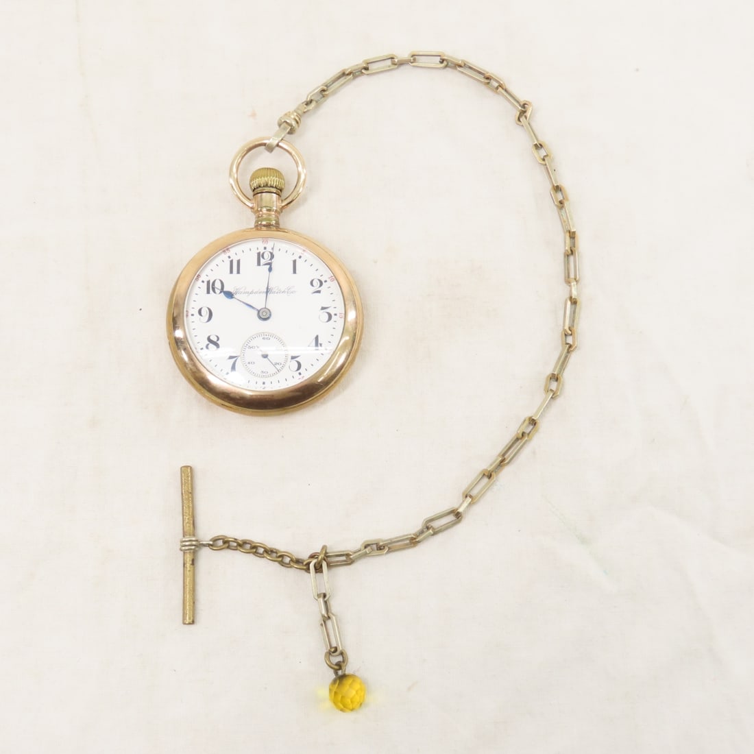 Hampden Working 17 jewel Open Face Pocket Watch: Hampden Working 17 jewel Open Face Pocket Watch - 1911 grade no.64, screw set, 18s, SN# 2865948, Philadelphia 20 year case- worn, with watch fob. Lot size: 3x3x1", .5 lb Photos are part of