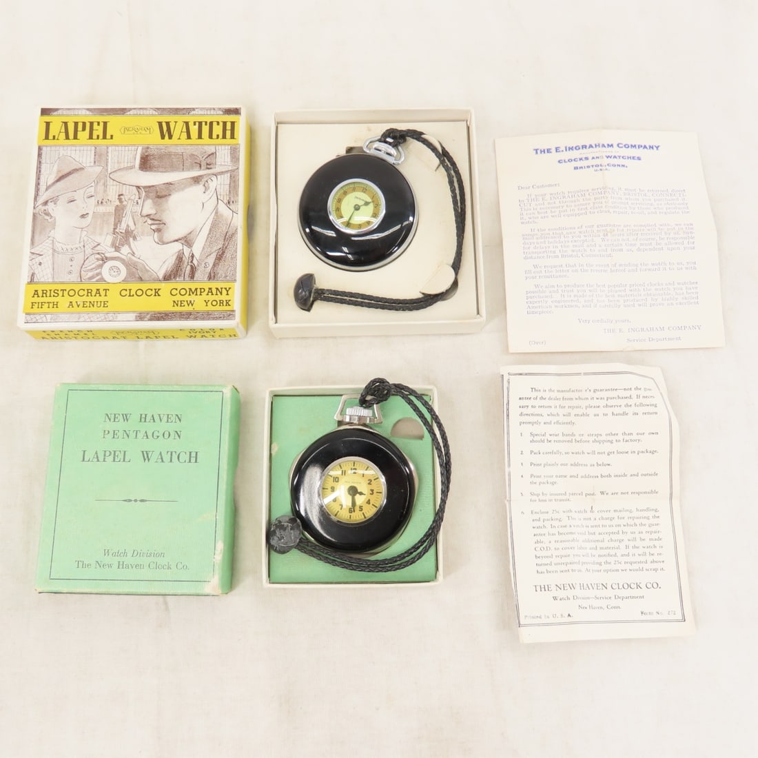 1930's Ingraham & New Haven Lapel Watches in Box: 1930's Ingraham & New Haven Lapel Watches in Box - both are working in boxes with leaflet. Black enamel with leather cords. Ingraham box is marked white not black so most likely not original. New