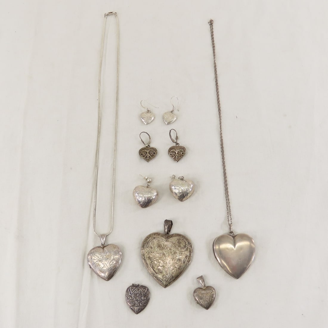Vintage Sterling Silver Heart Jewelry 81+ grams: Vintage Sterling Silver Heart Jewelry 81+ grams - 4 lockets, 2 chains, 1 pendant, and 3 pairs pierced earrings. Lot size: 4x4x4", 1.5 oz Photos are part of description. (Live Auctioneers only shows a