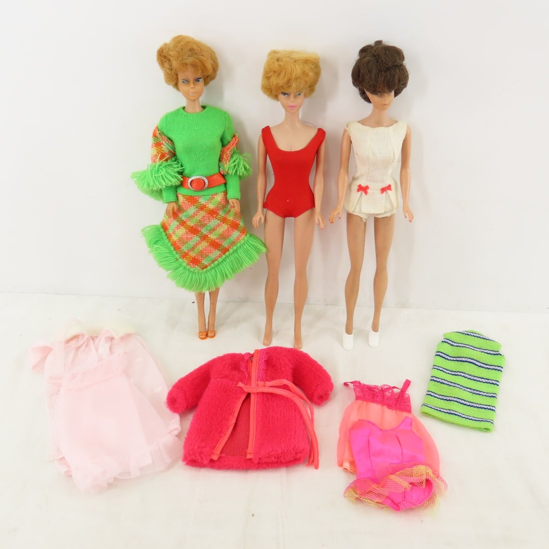 3 Bubblecut Barbies and Black Label Clothing: 3 Bubblecut Barbies and Black Label Clothing - 1) 1961-62 Blonde straight leg marked: "Barbie® Pats. Pend. © MCMLVIII by Mattel Inc.". JAPAN on right foot. 2) 1964 Blonde in plaid is marked: