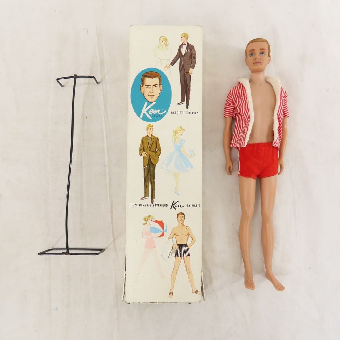 1961 Blonde Flocked Hair Ken 750 Doll in Box: 1961 Blonde Flocked Hair Ken 750 Doll in Box - with stand, flocking is worn, marked: "Ken™/Pats. Pend./© MCMLX/by/ Mattel/Inc.". In original swimsuit with jacket. Box top has broken