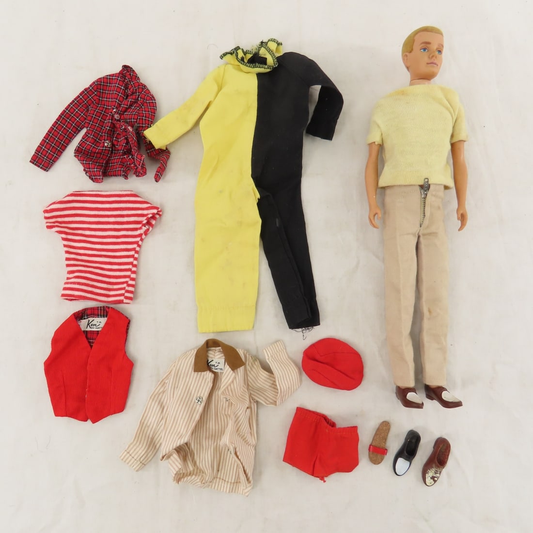 1961 Blonde Flocked Hair Ken 750 Doll: 1961 Blonde Flocked Hair Ken 750 Doll - flocking is worn, marked: "Ken™/Pats. Pend./© MCMLX/by/ Mattel/Inc.". Dressed in 782 Casuals. Extra clothing marked Ken and shoes. Lot size: