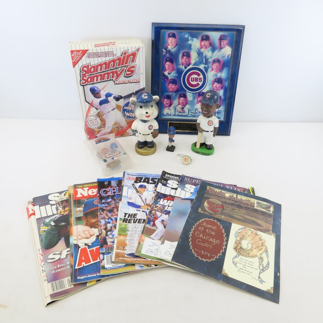 Sammy Sosa & Chicago Cubs Bobbleheads & More: Sammy Sosa & Chicago Cubs Bobbleheads & More - 1999 team photo mounted, wolf cub bobble head, magazines and more. 16x14x12", 10 lbs Photos are part of description. (Live Auctioneers only shows a max o