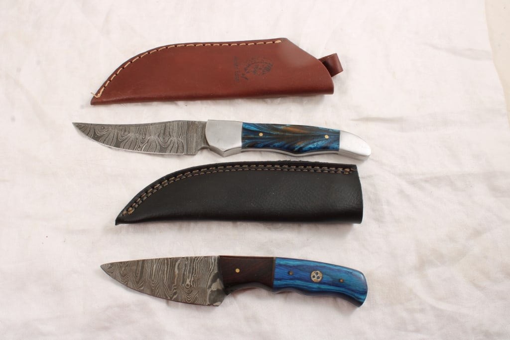 2 Damascus Fixed Blade Knives in Sheaths: 2 Damascus Fixed Blade Knives in Sheaths - Lot Size 11" x 4" x 5". 1 Lb. Photos are part of description (Live Auctioneers on displays a max of 20 photos -check other polatforms for all photos).