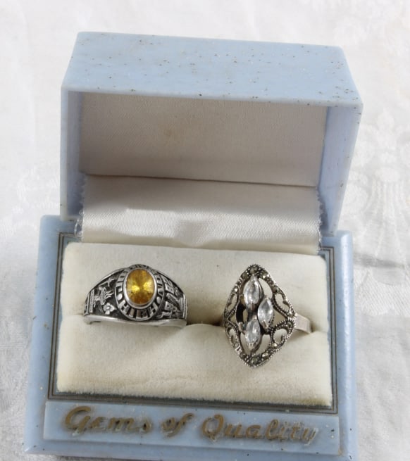 Uhrium Class Ring & Sterling Silver Ring: Uhrium Class Ring & Sterling Silver Ring - 1982 Johnson High School Uhrium 5.3 Grams Class Ring Size 8.5 and Sterling Silver and Rhinestone Size 7.5 Ring 4.2 Grams. Lot Size 3" x 2" x 2". 1