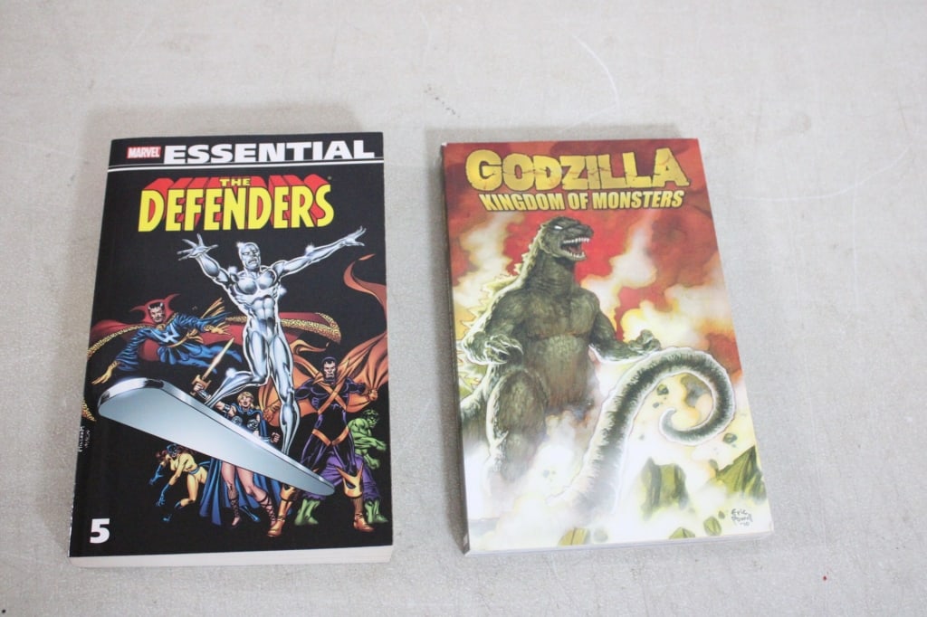 2 IDW & Marvel Essential Comic Books: 2 IDW & Marvel Essential Comic Books - IDW Godzilla Kingdom of Monsters Graphic Novel and Marvel Essential The Defenders #5. Lot Size 10" x 7" x 2". 3 Lbs. Photos are part of description (Live