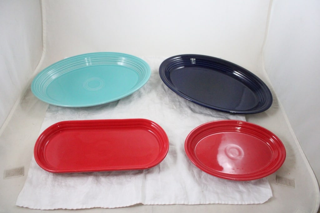 4 Fiesta HLC Serving Platters: 4 Fiesta HLC Serving Platters - 13.5" Turquoise Platter, 13.5" Cobalt Platter, 12" Scarlet Oblong Platter, 9.5" Scarlet Oval Platter. Lot Size 14" x 10" x 8". 8 Lbs. Photos are part of
