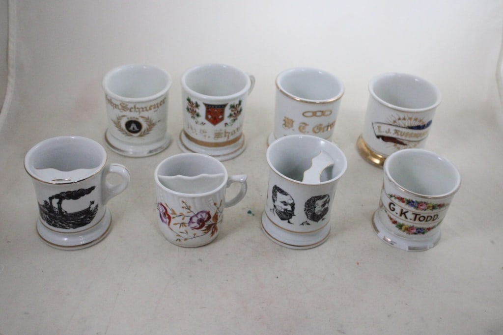 8 Antique Shaving Mugs & Moustache Cups: 8 Antique Shaving Mugs & Moustache Cups - 5 Shaving Mugs have some chips. Moustache Cups look good. Lot Size 10" x 15" x 11". 7 Lbs. Photos are part of description (Live Auctioneers on