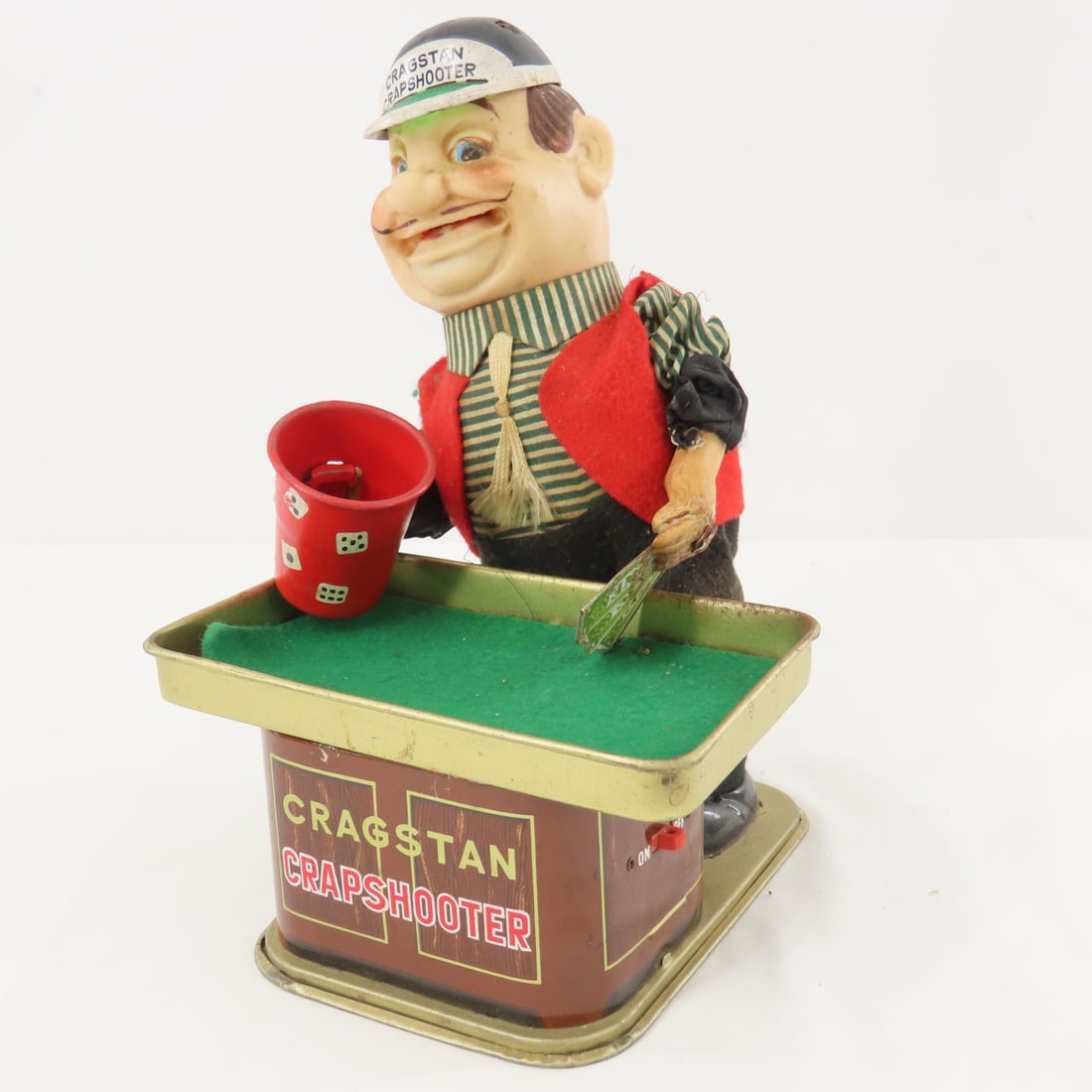 1950's Cragstan Crapshooter by Yonezawa Japan: 1950's Cragstan Crapshooter by Yonezawa Japan - battery operated, does not work, rust in battery compartment, , hand with cards has been repaired, tin litho, plastic & fabric. LOT SIZE: 9x6x7" 1 LB